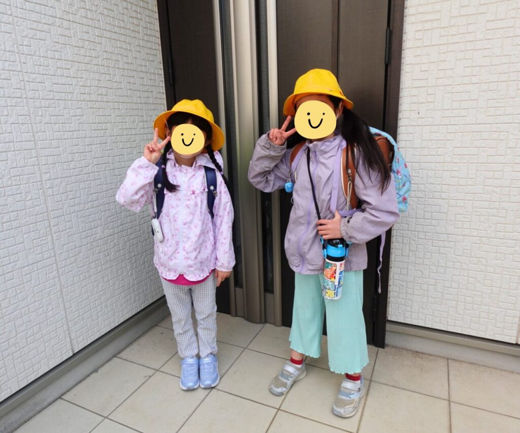 登校準備が完了し玄関に並ぶ小学1年生と2年生の姉妹